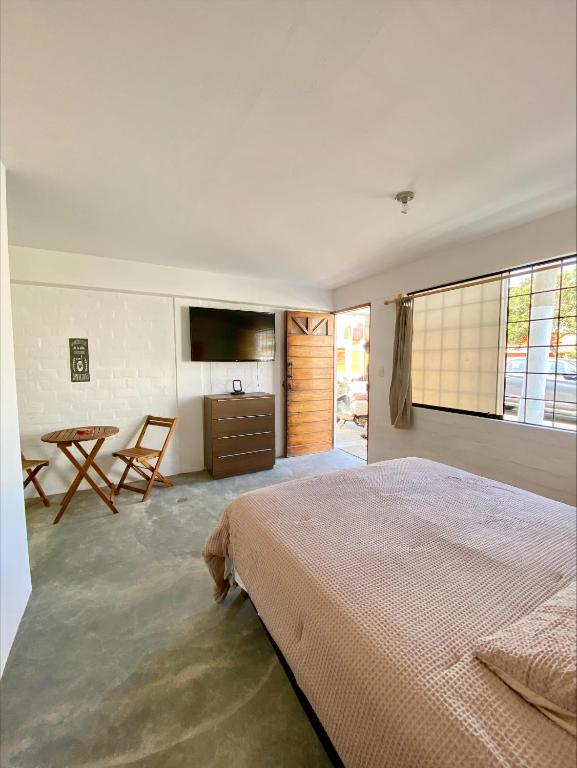 a bedroom with a bed and a table and a television at Casa Danda Punta Hermosa in Punta Hermosa