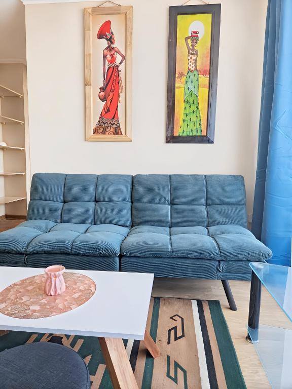 a living room with a blue couch and a table at Amplio y Cómodo departamento in Temuco