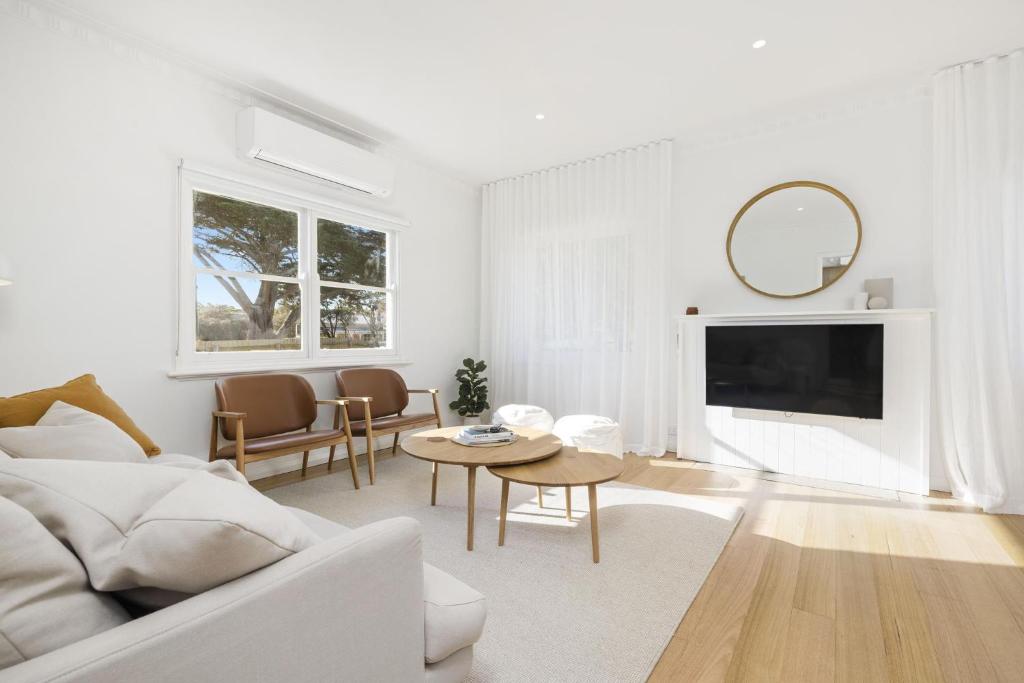 a white living room with a couch and a table at The Village Belle - Stay In The Heart of Sorrento in Sorrento
