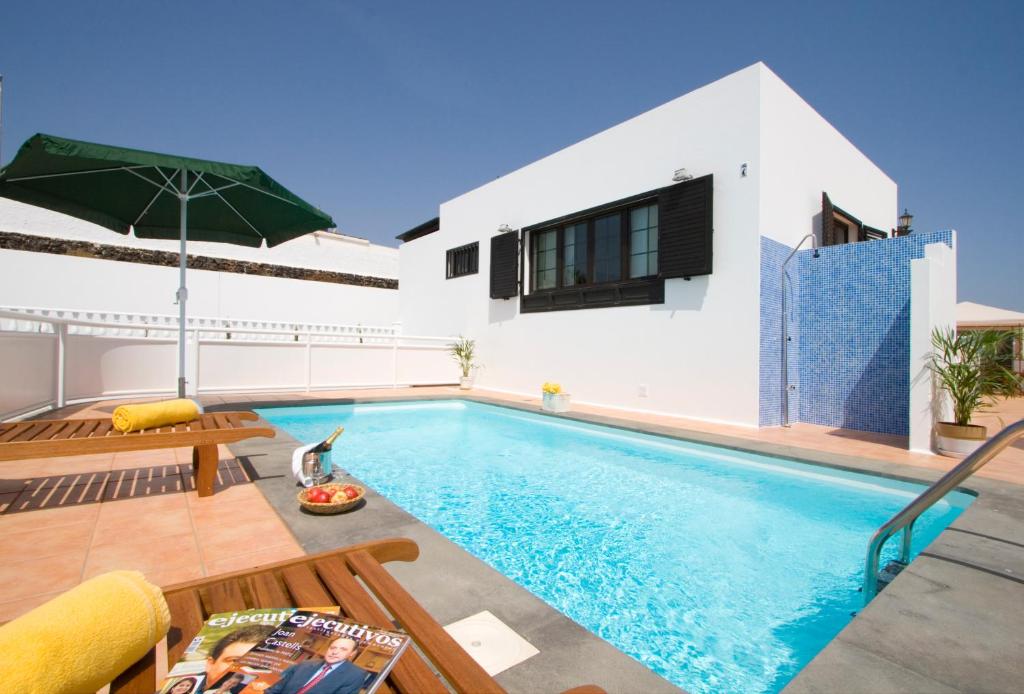 a villa with a swimming pool and a house at Grand Villa Famara Los Mojones by Dolores in Puerto del Carmen