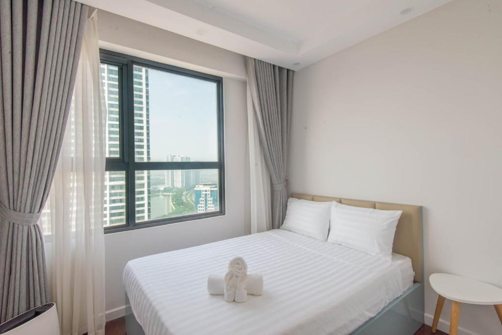河内Harmony Vinhomes D'Capitale的一只泰迪熊坐在卧室的床上