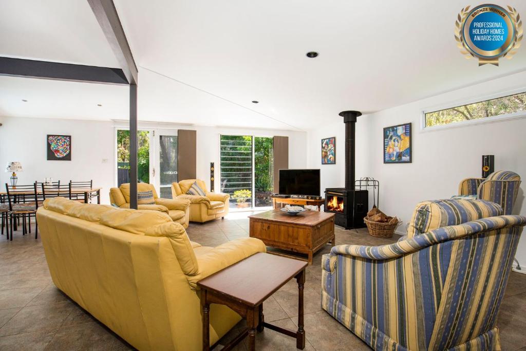 un ampio soggiorno con divani e TV di Grey Gables - Pet Friendly with Fireplace, Pool, Spa & Sauna a Callala Bay