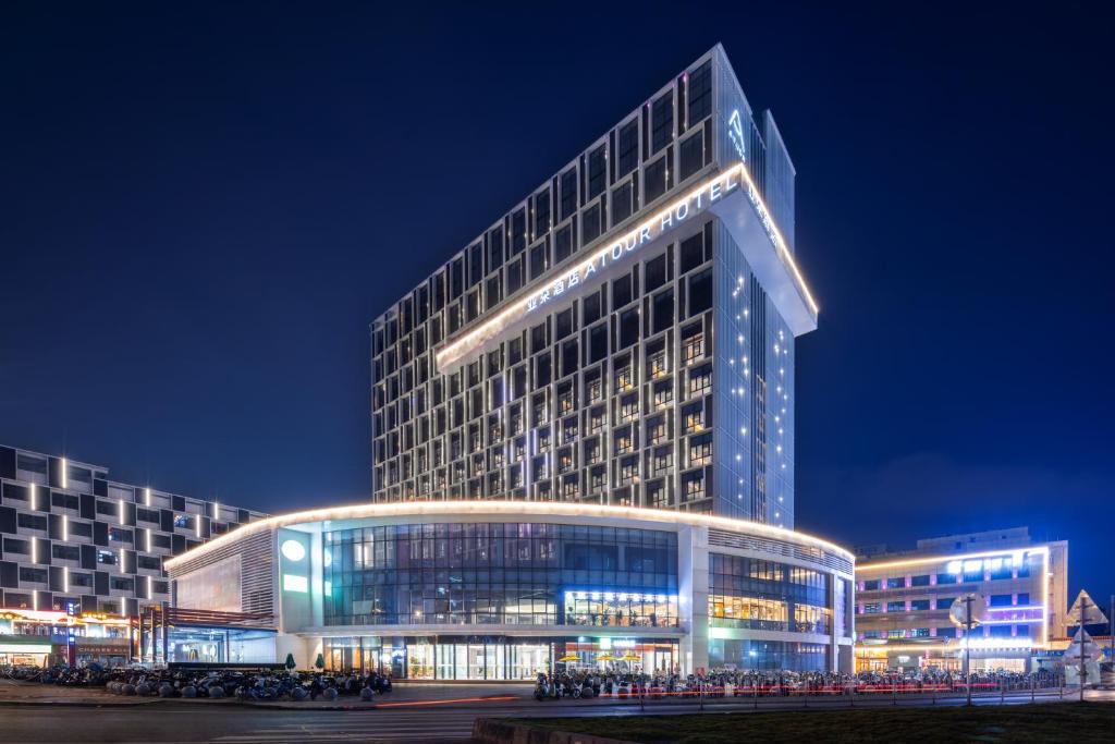 a large building with lights on it at night at Atour Hotel Guangzhou Baiyun Station Julong Metro Station in Guangzhou