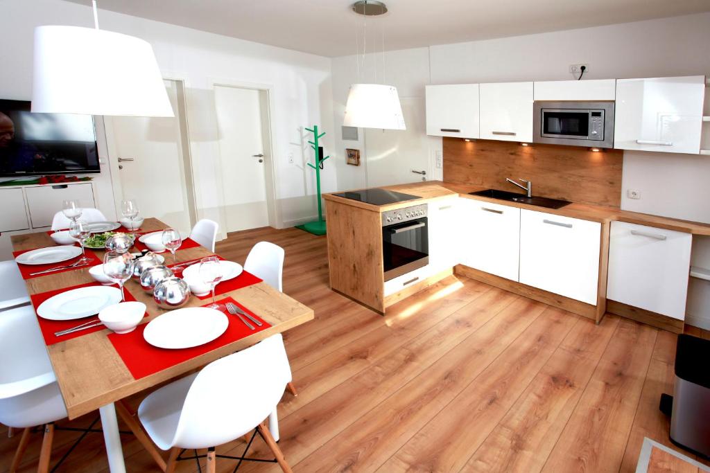 a kitchen with a wooden table and white cabinets at großes SchützenChalet in Braunlage