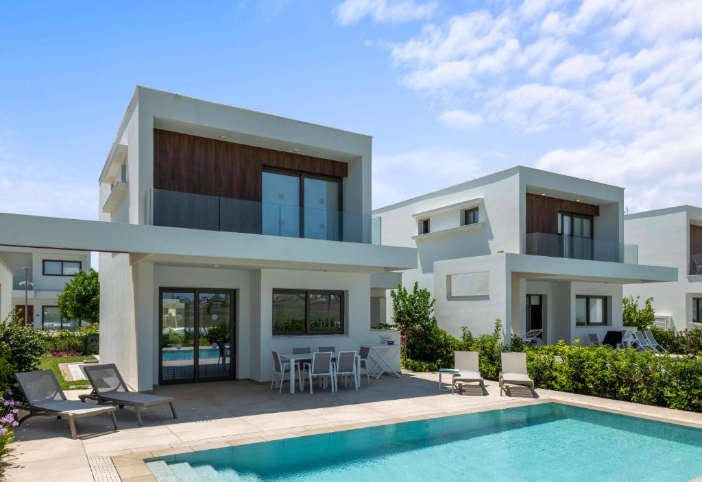 una villa con piscina y una casa en Serenity Waves Villa 16, en Lárnaca