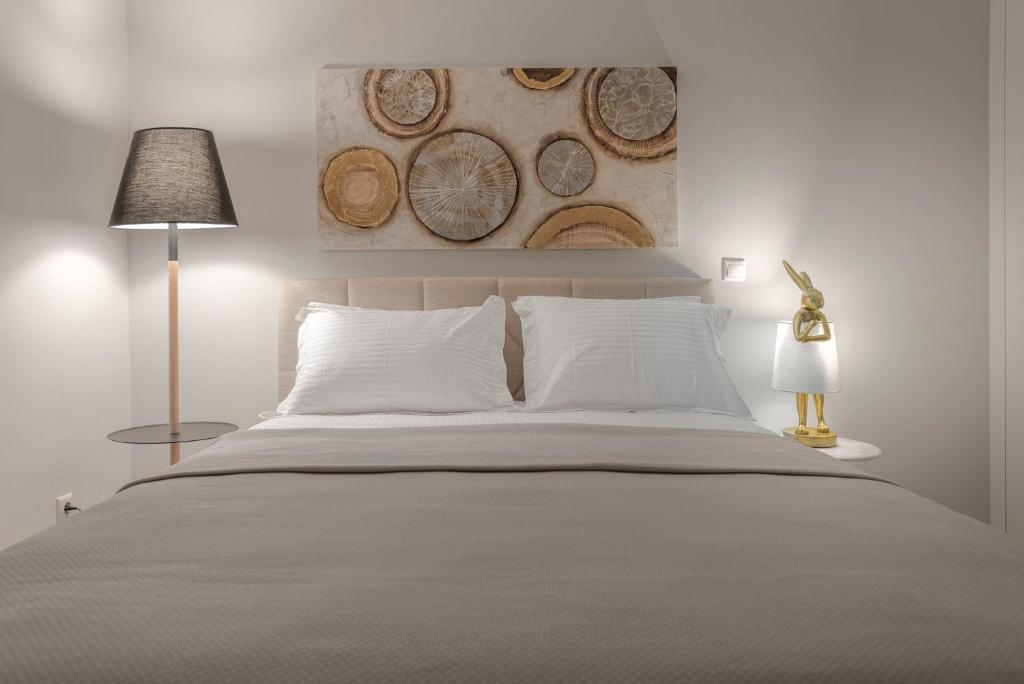 1 dormitorio blanco con 1 cama grande con almohadas blancas en Agias Sofias 28, en Tesalónica