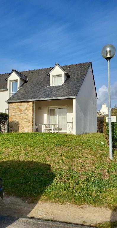 une maison sur une colline avec une table devant elle dans l'établissement Maison mer et piscine 3 nuits minimum, à Loc-Maria-Plouzané
