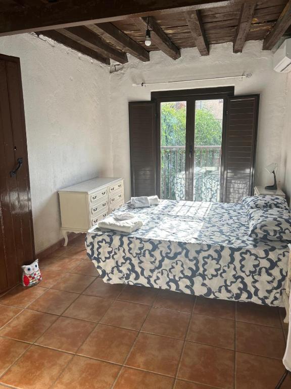 a bedroom with a bed and a window at La Posada De Alanah in Candeleda