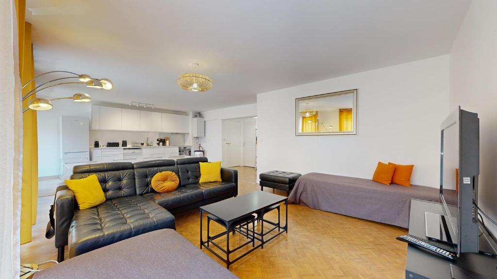 - un salon avec un canapé et une télévision dans l'établissement Les terrasses de Saint Georges 100m clim Parking, à Toulouse