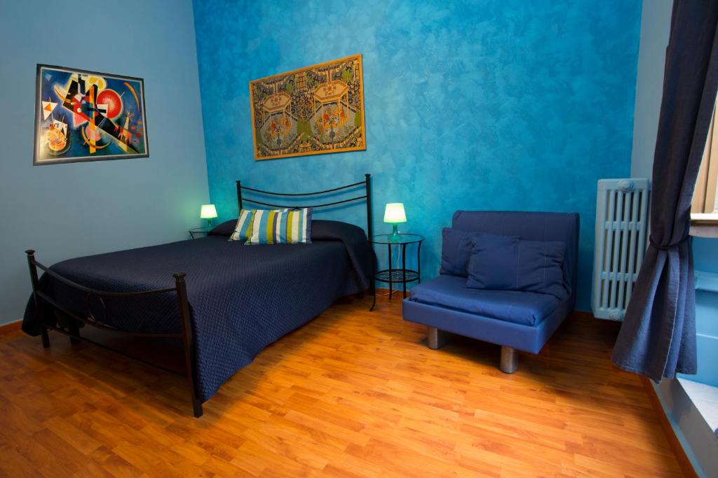 1 dormitorio con paredes azules, 1 cama y 1 silla azul en Laterano Inn, en Roma