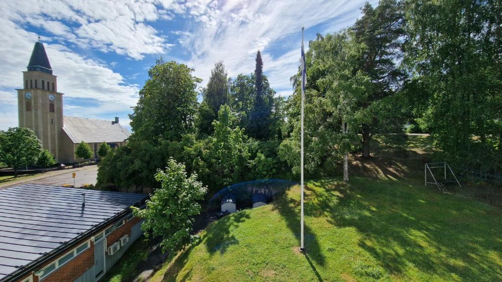 a church with a clock tower and a grassy hill at Villa Ruths Stay Valta in Kouvola