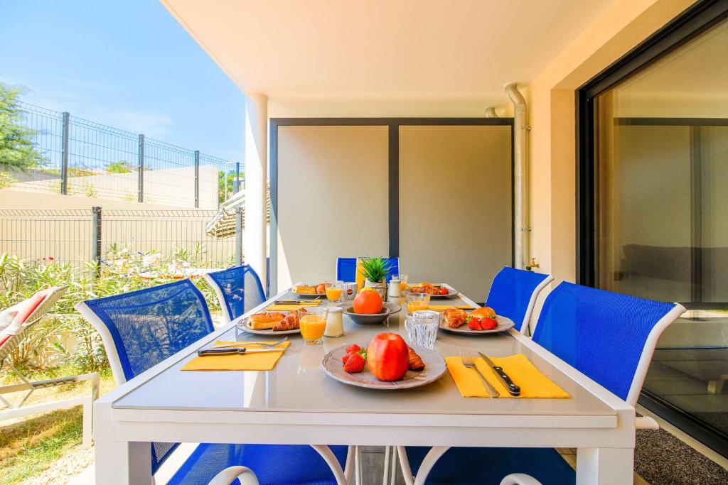 - une table avec des assiettes de fruits sur la terrasse dans l'établissement SELECT'soHOME - Appartement pour 5 personnes idéalement situé à proximité de la plage et des commerces de La Favière ! - ILOA-B04, à Bormes-les-Mimosas