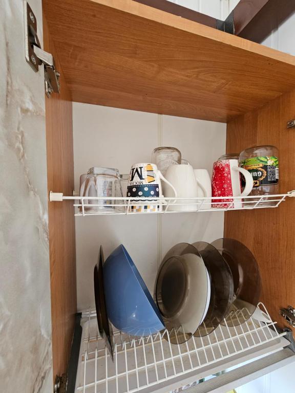 a cupboard filled with dishes and other kitchen items at UZDARYTAS Siguldas 21 in Liepāja