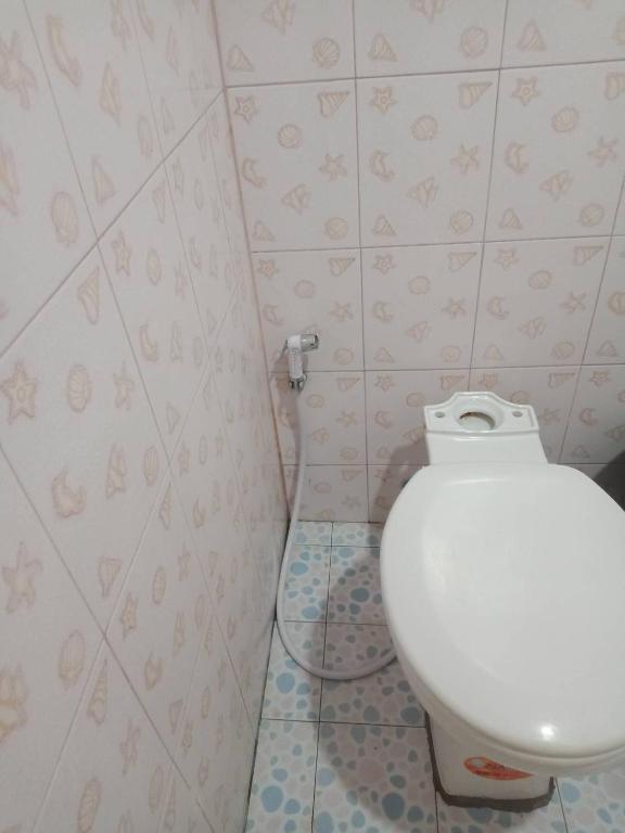 a bathroom with a white toilet in a room at มังกรเลโฮสเทล Mangkonlay Hostel in Ban Khlong Pak