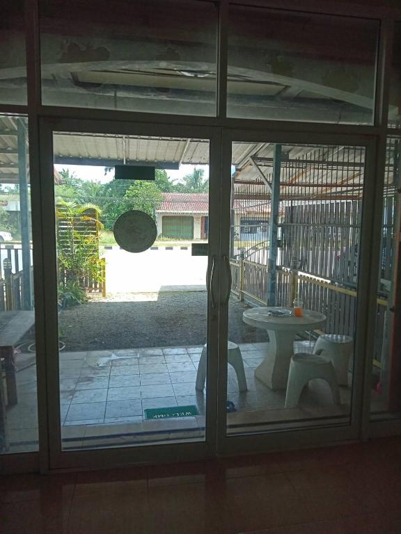 a view of a patio through a glass door at มังกรเลโฮสเทล Mangkonlay Hostel in Ban Khlong Pak