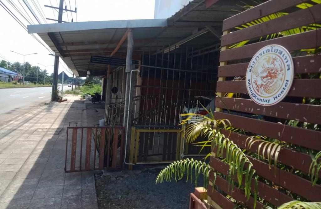 a building with a sign on the side of it at มังกรเลโฮสเทล Mangkonlay Hostel in Ban Khlong Pak