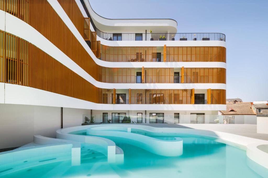 a swimming pool in front of a building at Baltic Waves Resort by PI Apartments - Official Operator in Międzyzdroje