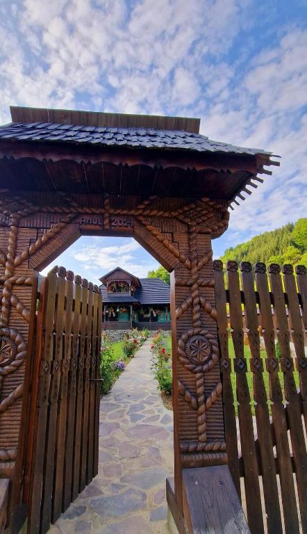 RozavleaにあるCasutele Paul de pe Valeの建物の前にある木製のアーチが付いた木製のフェンス