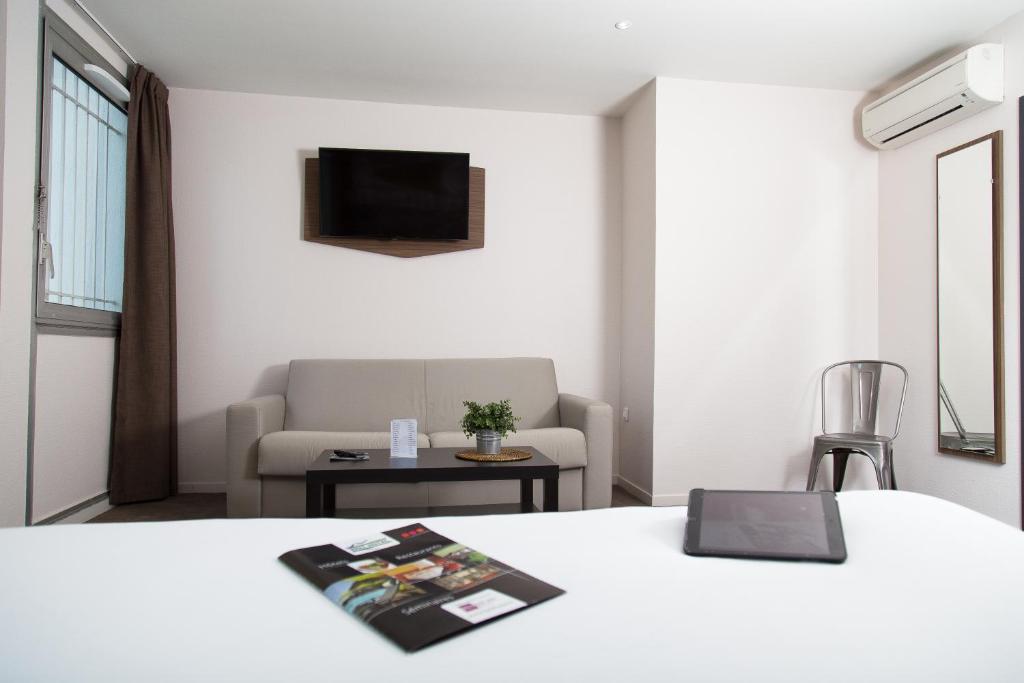 Rúm í herbergi á Brit Hotel Toulouse Colomiers – L’Esplanade