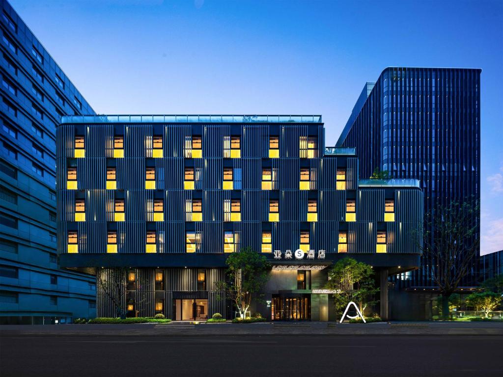 an office building with lights on in a city at Atour S Hotel Tianshan Road in Shanghai