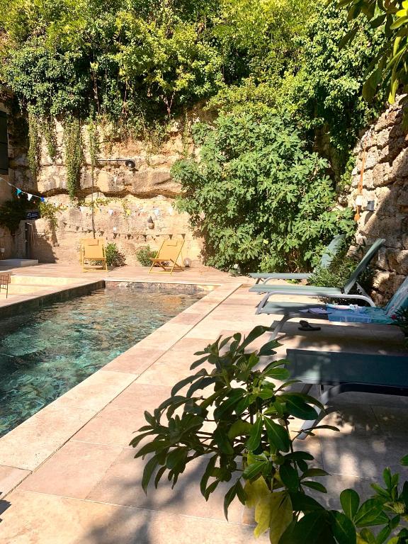 - une piscine dans une cour avec des chaises et des arbres dans l'établissement villa dans l entre deux mers secteur saint Emilion sauternes, à Verdelais