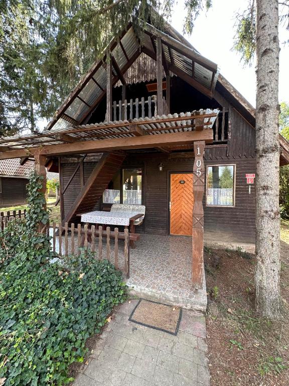 a house with a porch and a wooden door at 2 hálószobás vendégház in Balatonboglár