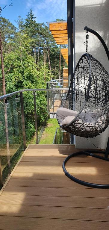 a porch with a swing on a balcony at Pobierowo City in Pobierowo