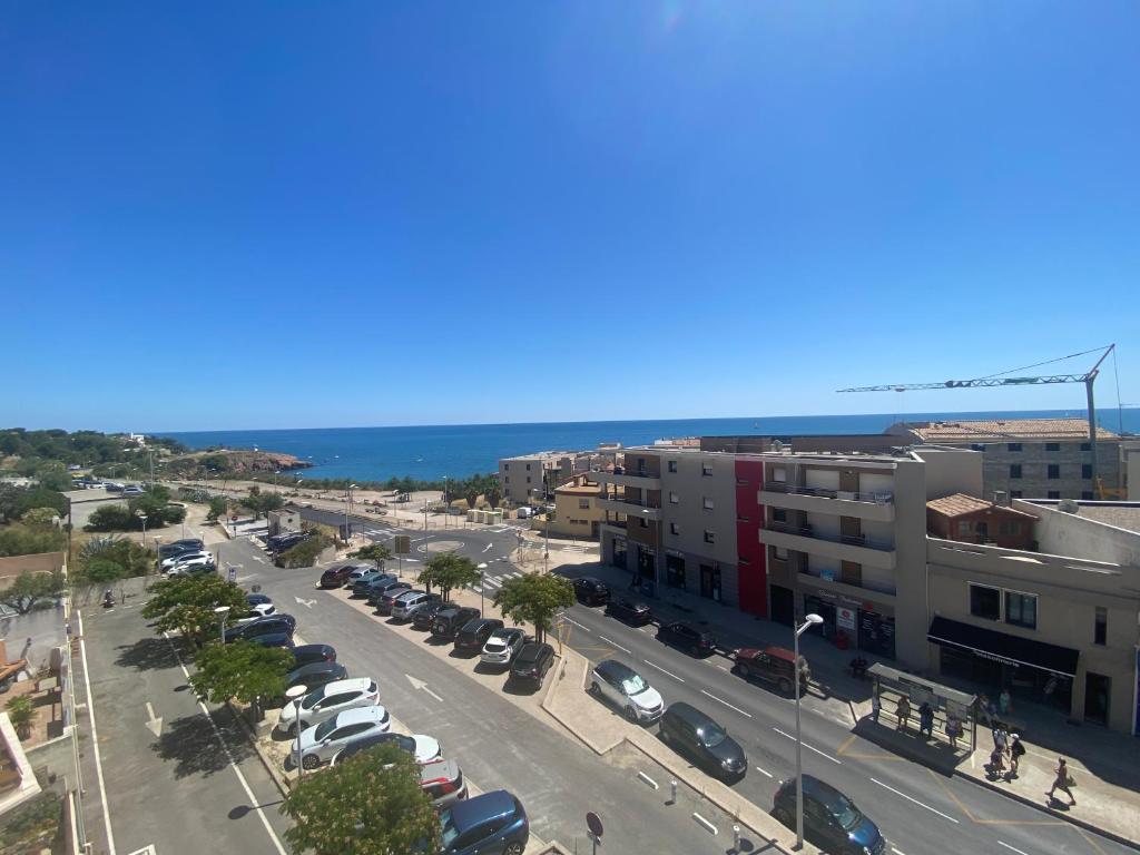 une rue de la ville avec des voitures garées dans un parking dans l'établissement Petit cocon vue sur la corniche de Sete, à Sète