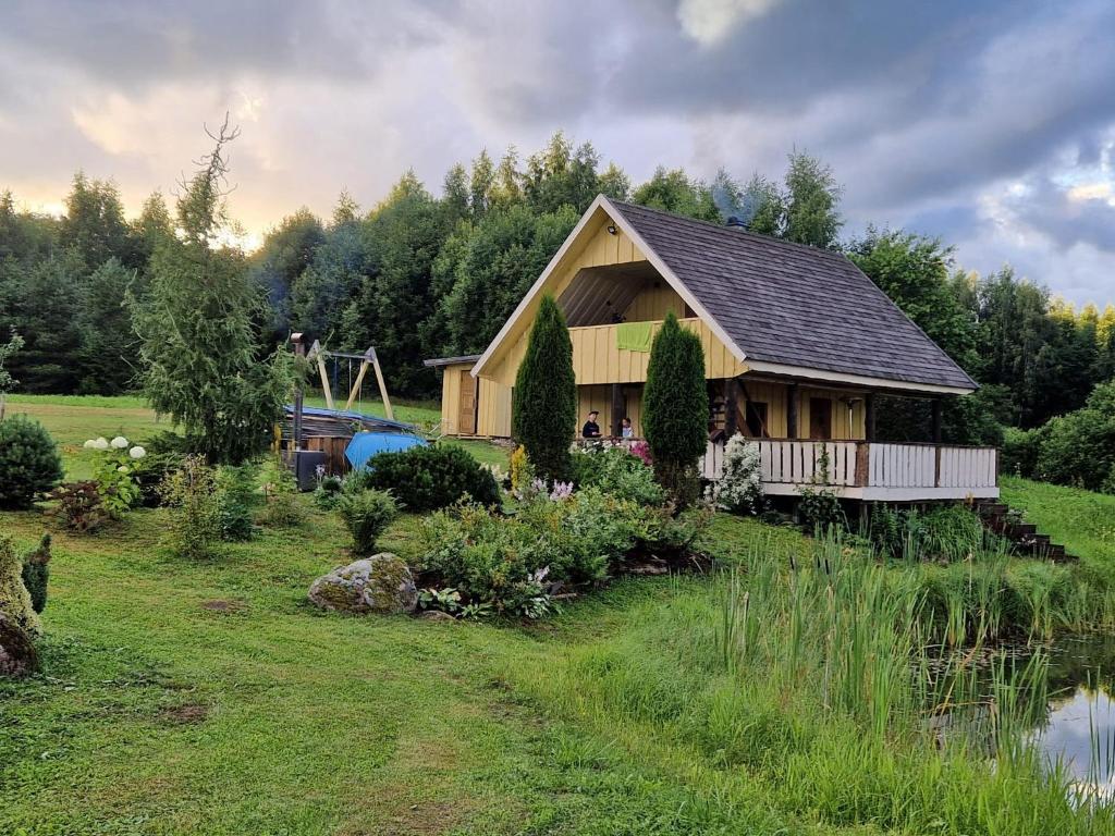 a house in a field next to a river at Üleoja Saunaholiday in Kaagvere