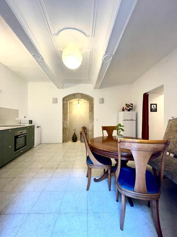 a kitchen with a table and chairs in a room at Belle maison Centre Sérignan in Sérignan