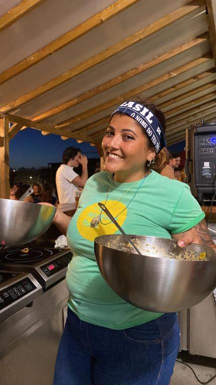 a woman standing in a kitchen holding a bowl at WOT Ericeira Surf Hostel in Ericeira