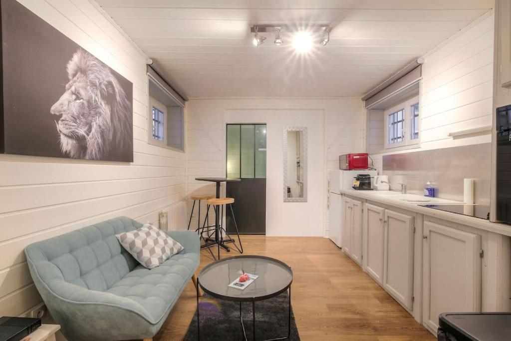 un salon avec un canapé et une table dans l'établissement Appartement bien équipé, Croix-Rousse, Lyon, à Lyon