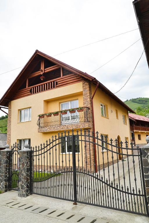 a house with a black fence in front of it at Pensiunea Dorina in Botiza