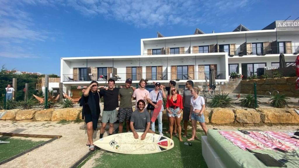 a group of people posing for a picture in front of a building at WOT Ericeira Surf Hostel in Ericeira