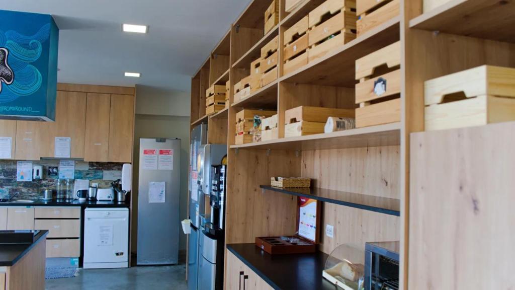 a kitchen with wooden cabinets and a refrigerator at WOT Ericeira Surf Hostel in Ericeira