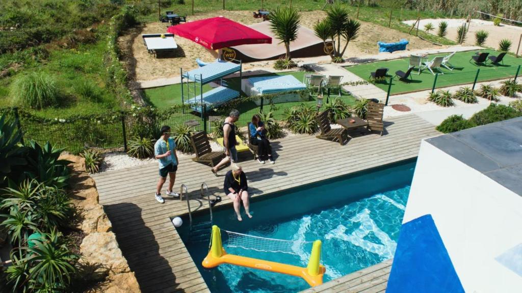 a group of people standing around a swimming pool at WOT Ericeira Surf Hostel in Ericeira