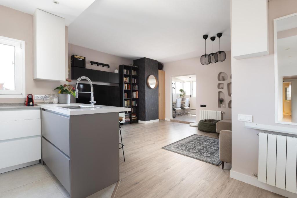 Hotel Fantastic view penthouse apartment, a kitchen and living room with white cabinets and a sink at Fantastic view penthouse apartment in Barcelona