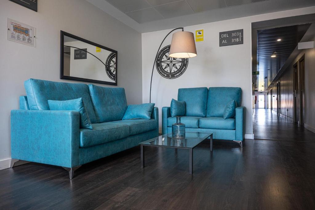 a living room with two blue couches and a table at Pato Rojo in Punta Umbría