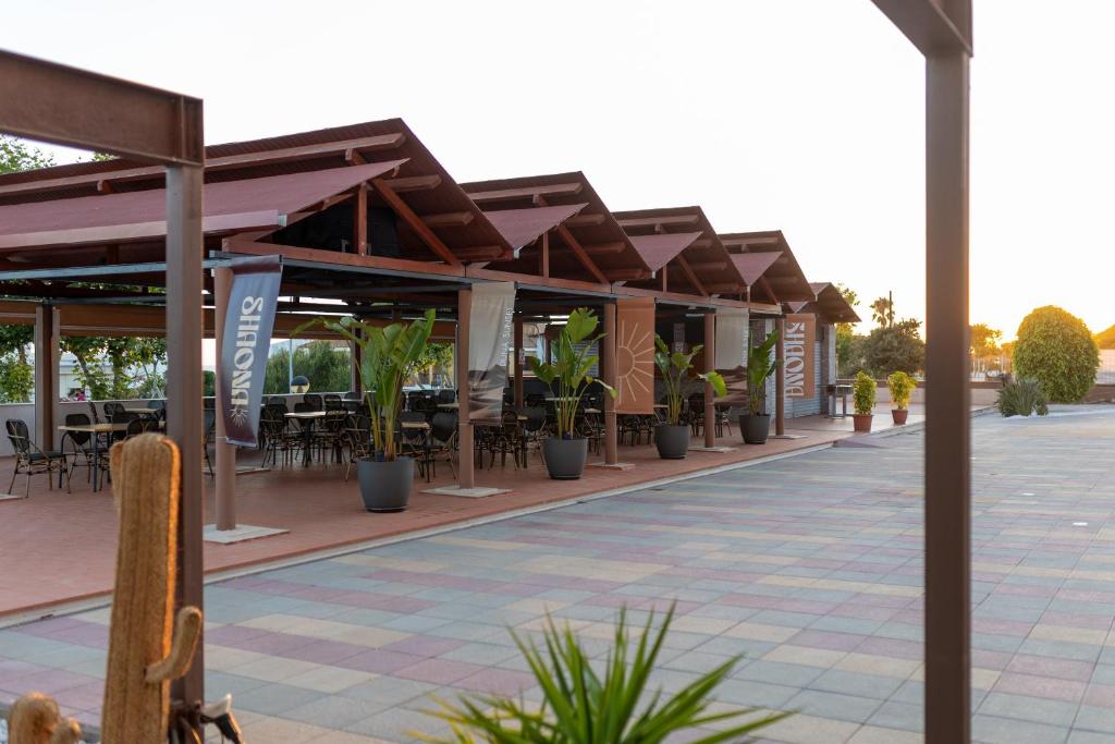 an outdoor patio with tables and chairs and plants at Pato Rojo in Punta Umbría