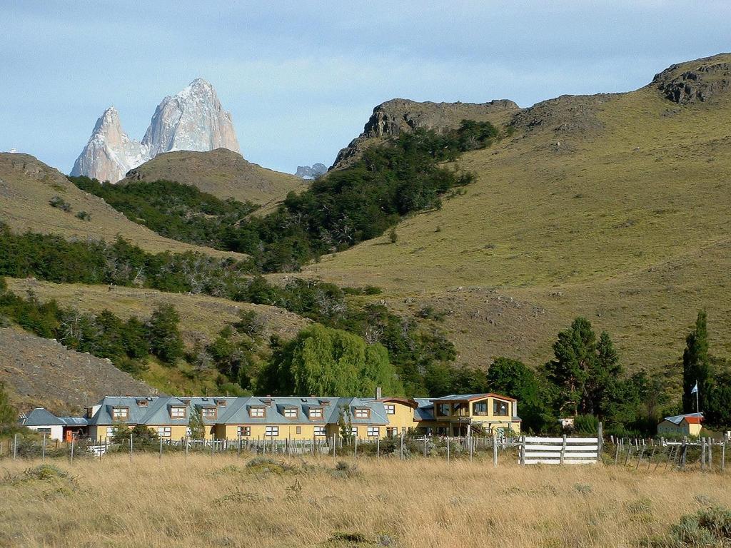 ein Haus auf einem Hügel mit Bergen im Hintergrund in der Unterkunft Estancia La Quinta in El Chalten