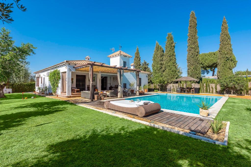 a house with a swimming pool in a yard at Casa Rural La Teja in Marchena