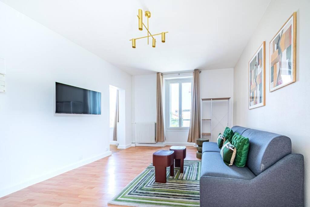 un salon avec un canapé et une télévision dans l'établissement Appartement spacieux et calme Ville de Issy, à Issy-les-Moulineaux
