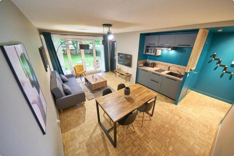 un salon avec une table et une cuisine dans l'établissement Le patio AIL, à Lyon