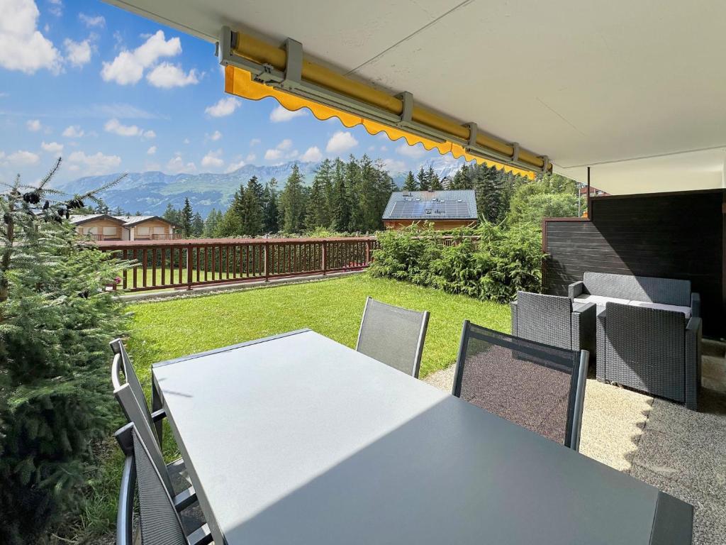 a table and chairs on a patio with a view at Valdor Residence- Crans Montana- Swiss Alps in Crans-Montana