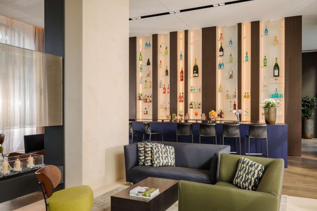 a lobby with a couch and a bar at Hilton Lake Como in Como