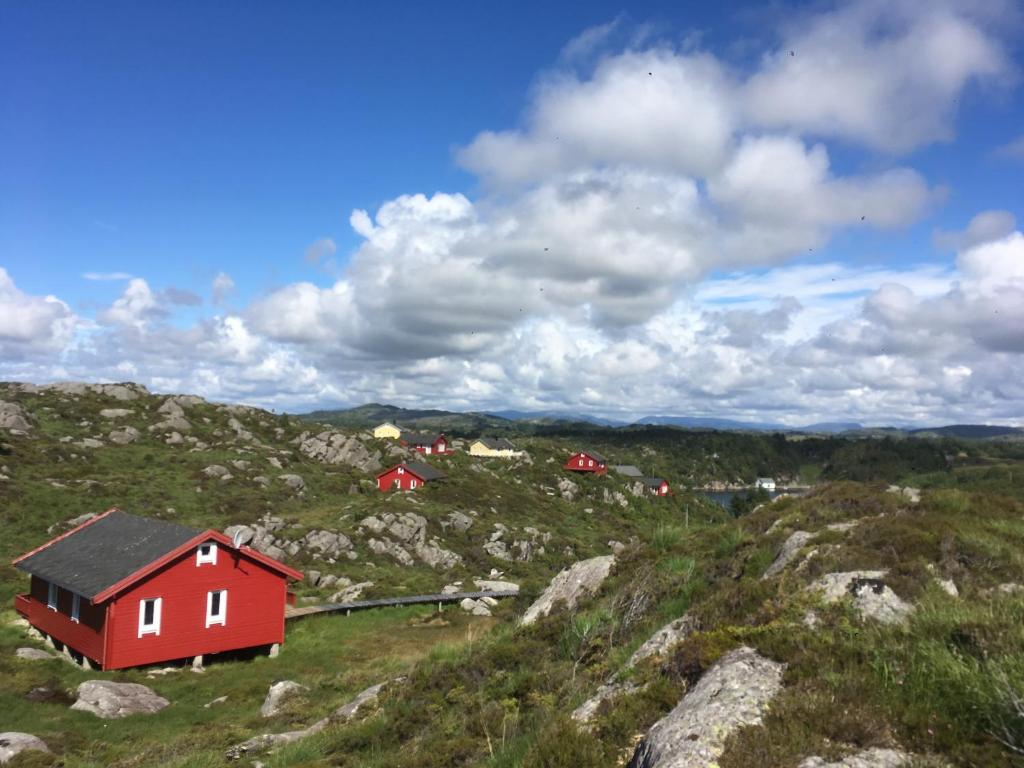 a red house on the side of a mountain at Hagland Lille Haugesund 8x Ferienhaus incl Motorboot in Hagland