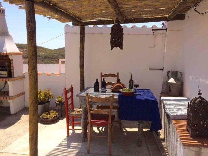 a table with chairs and a blue table cloth on a patio at Casa Papoula in Tavira