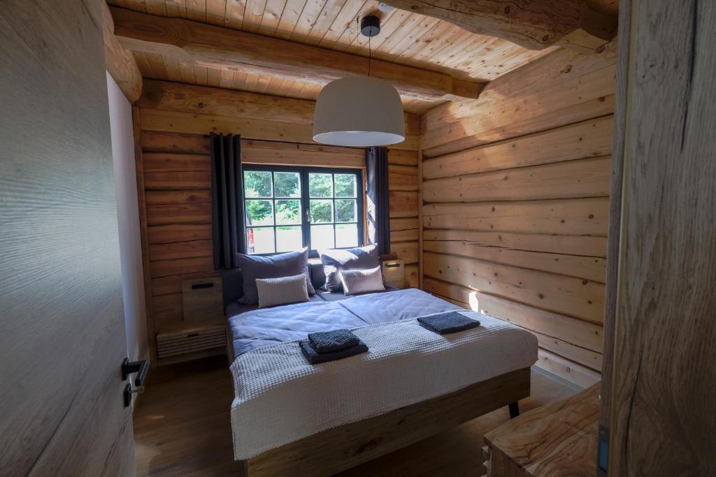 sypialnia z łóżkiem w chacie z bali w obiekcie wunderschönes Blockhaus direkt am See für 10 PAX w mieście Gröbern