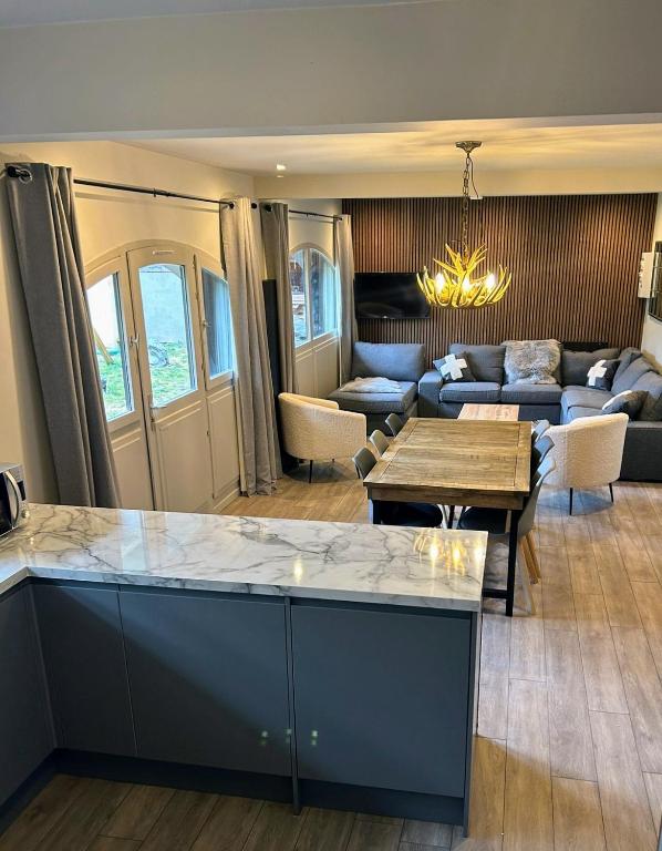 une cuisine et un salon avec une table et un canapé dans l'établissement Summer Alps Apartment, à Saint-Martin-de-Belleville