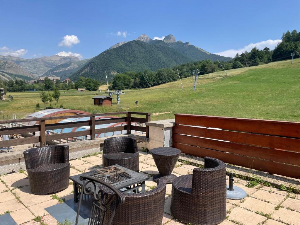 a patio with a table and chairs and a fence at Le Logis de Bamby in Ancelle